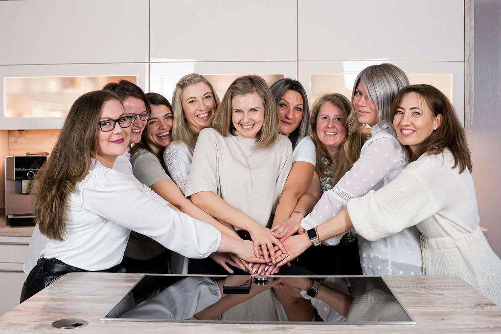 Ein Teil der Kitchenlove Crew, alle Hände in der Mitte, in einer Küche